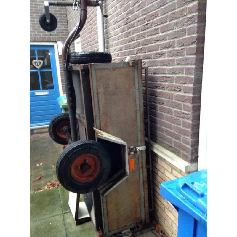 een kleine aanhangwagen, met gesloten deksel, zeil en net   Mijn schoonouders hebben deze aanhangwagen vaker gebruikt als zij op vakantie gingen in NL. Nu zij 