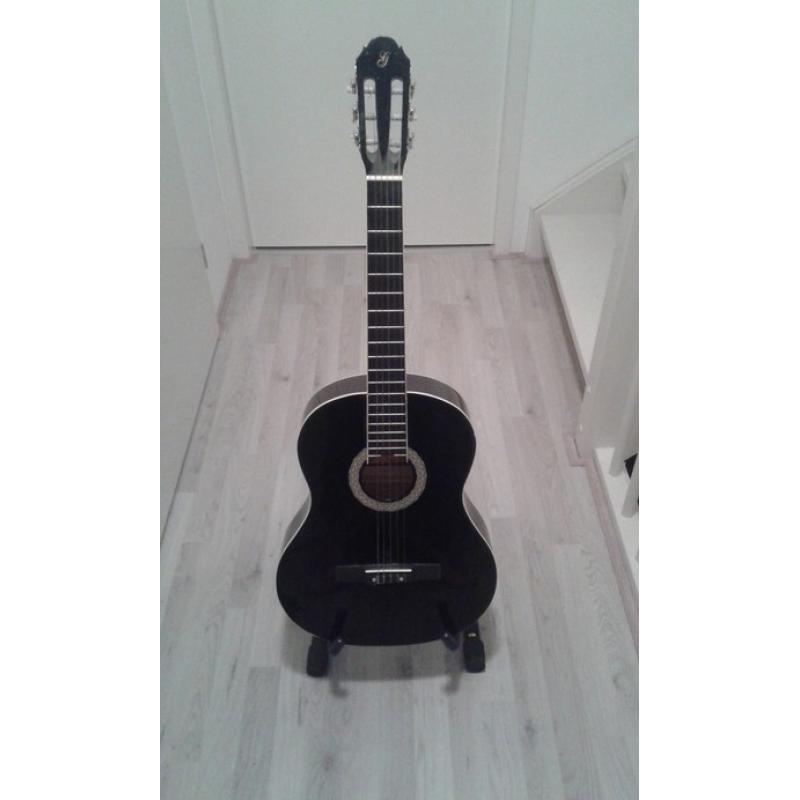 Gitaar + Gratis gitaarstandaard   Leuke giraar met een gratis gitaarstandaard. Bijna nooit op gespeeld, was er meer voor de sier  